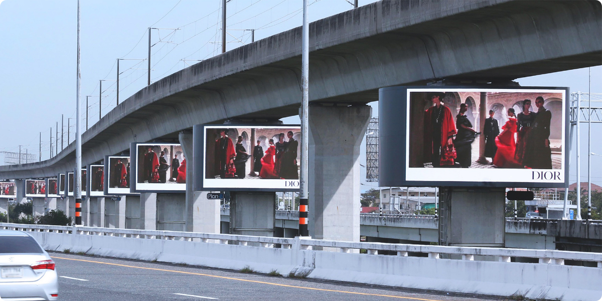 Many of the same Dior billboards in a line down a highway